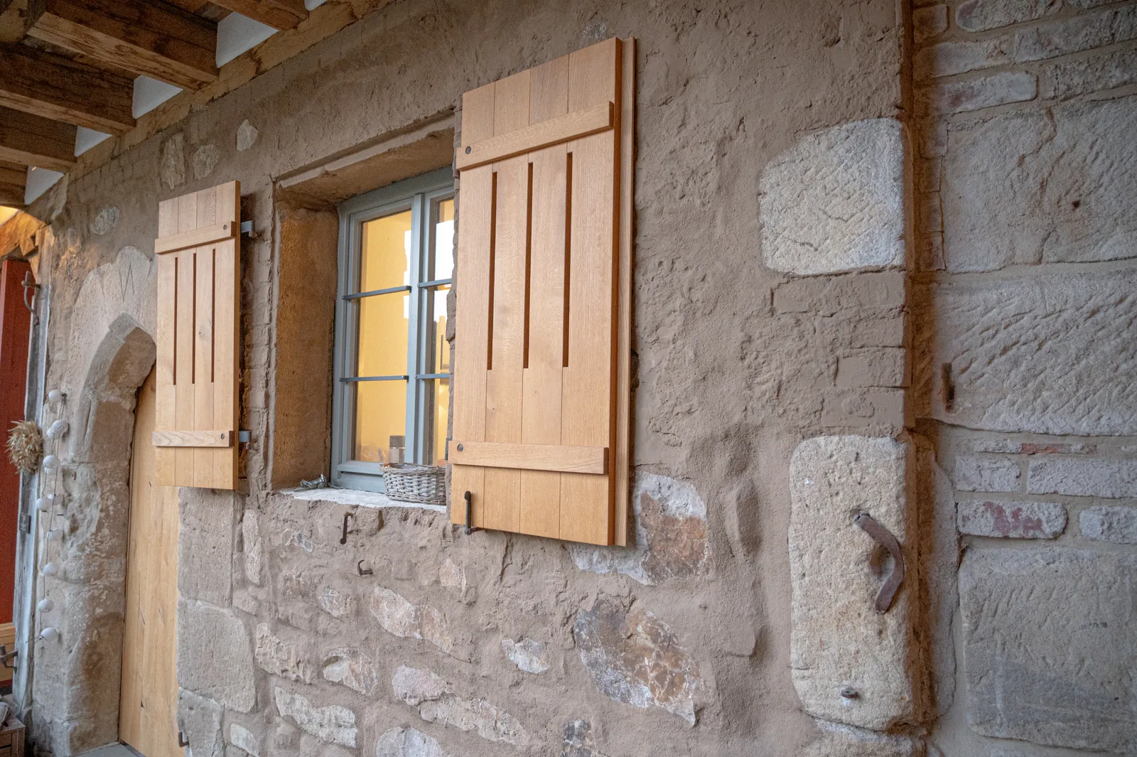Historische Sandsteinmauer mit neuem Holzfensterladen