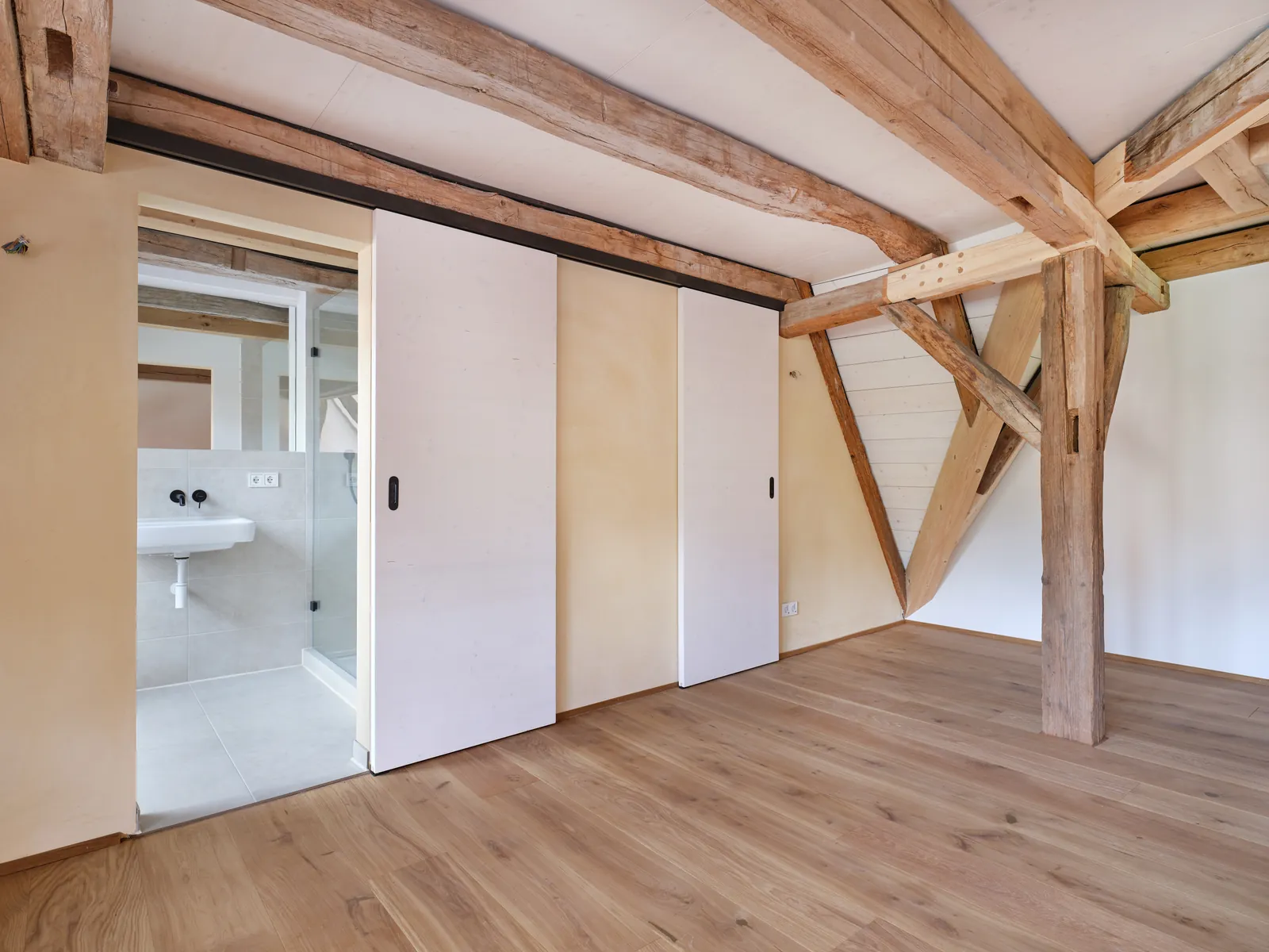 Dachzimmer mit Schiebetür zum Bad