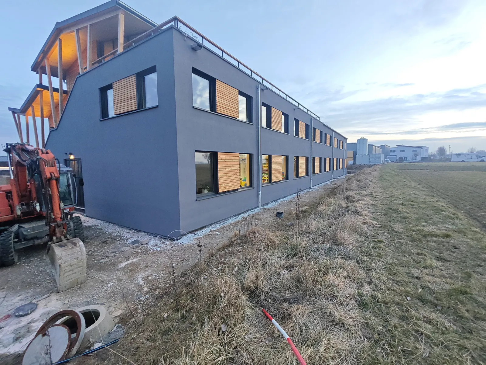 Neubau Kusterdingen, verputzte Längsfassade während der Außenanlagen